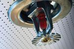 Close-up of fire sprinkler head adhered to ceiling