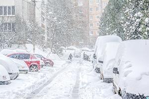 Snow covered street with cars