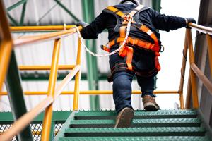 man with fall protection walking up stairs