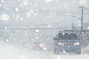 Motorists driving on a city street in white out conditions